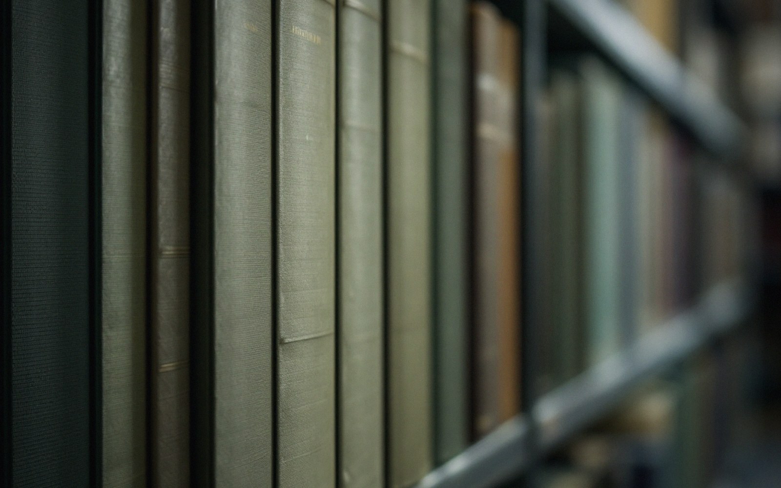 Spiral-bound large-print volumes stacked on a library trolley